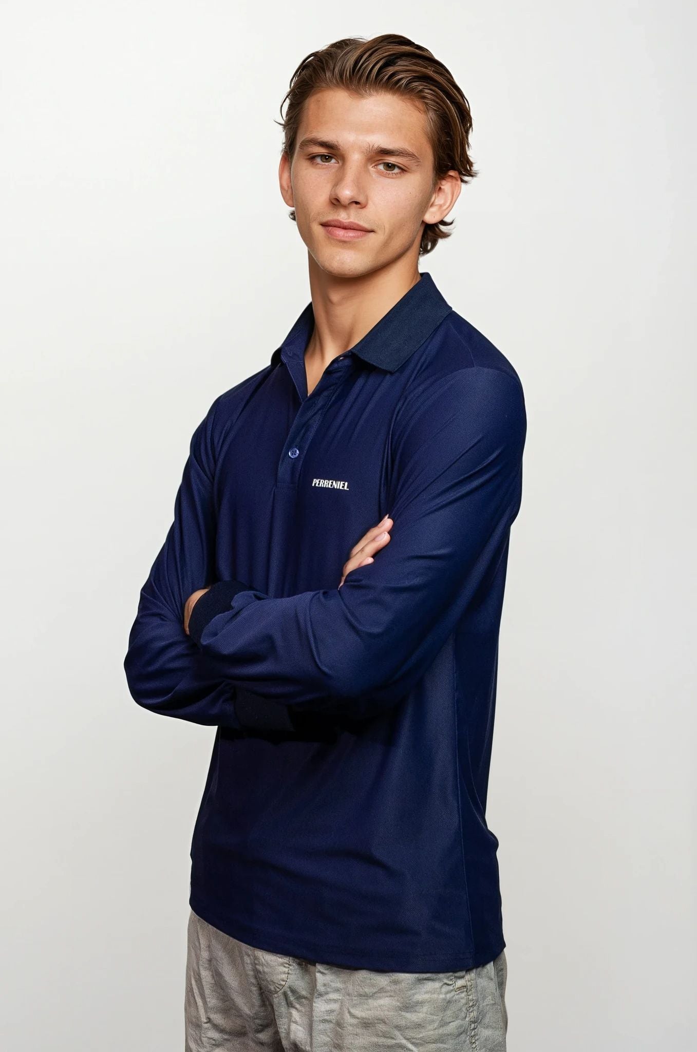 Man wearing a navy long-sleeve shirt with a perreniel logo on a white background